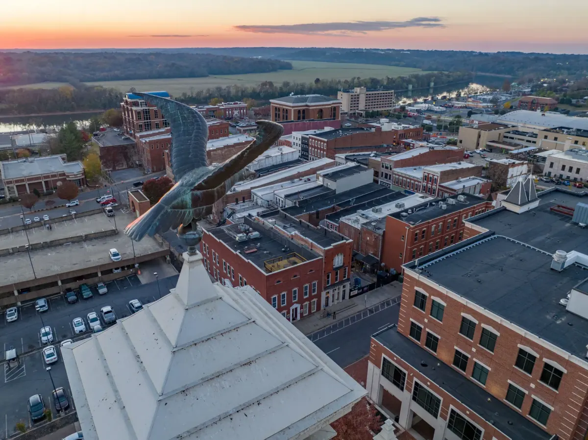 Aerial view over downtown Clarksville rooftops toward the Cumberland River at sunset