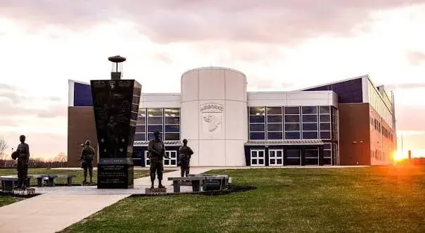 A building at Fort Campbell with monuments and statues outside at sunset